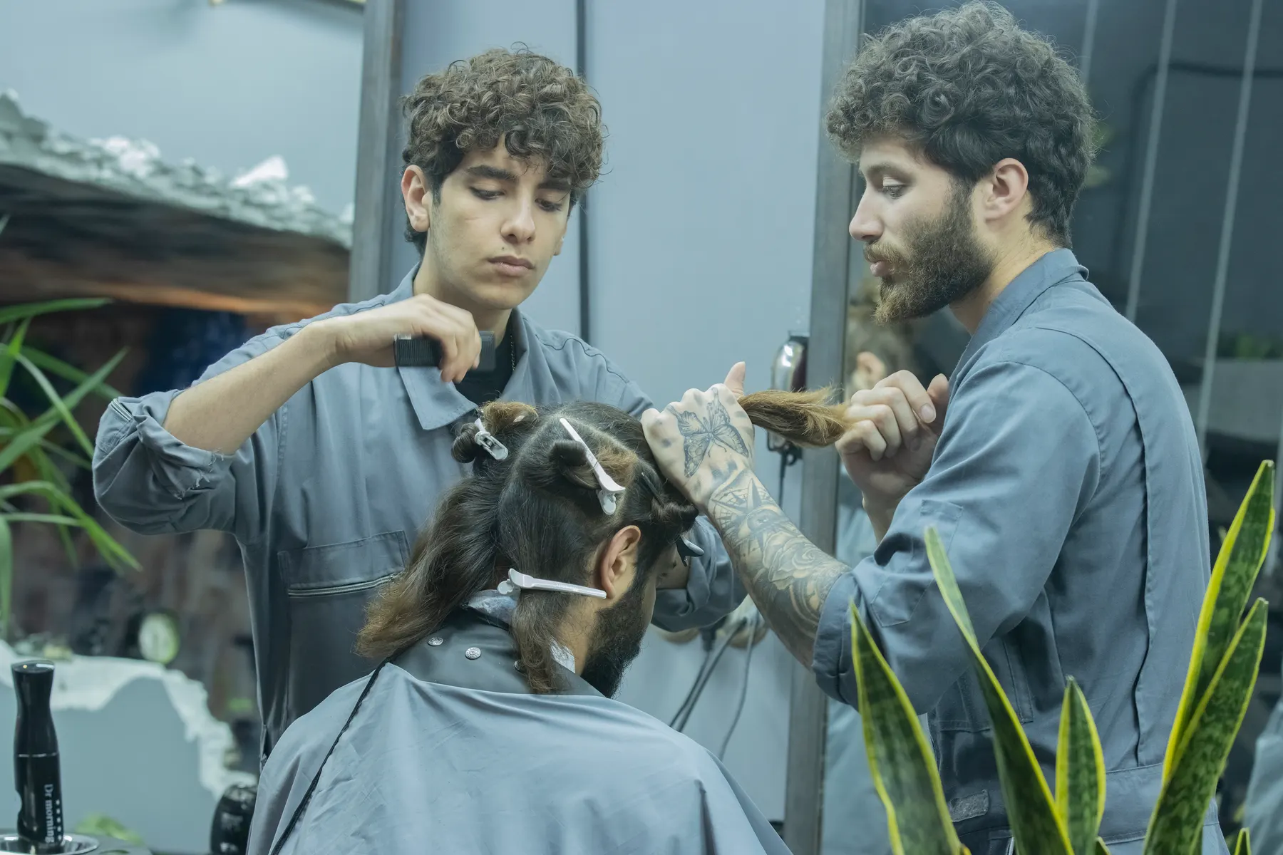 Stylist hand painting lightener through mid lengths of hair