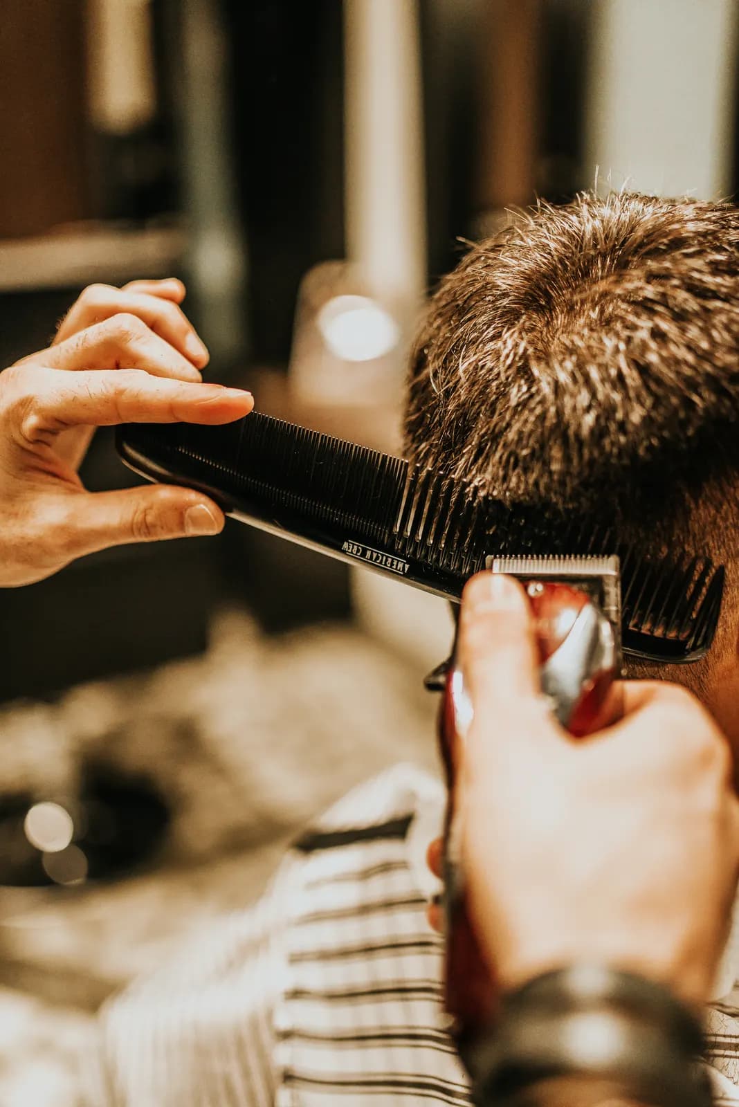 Close crop of a haircut in progress, comb held against the hairline