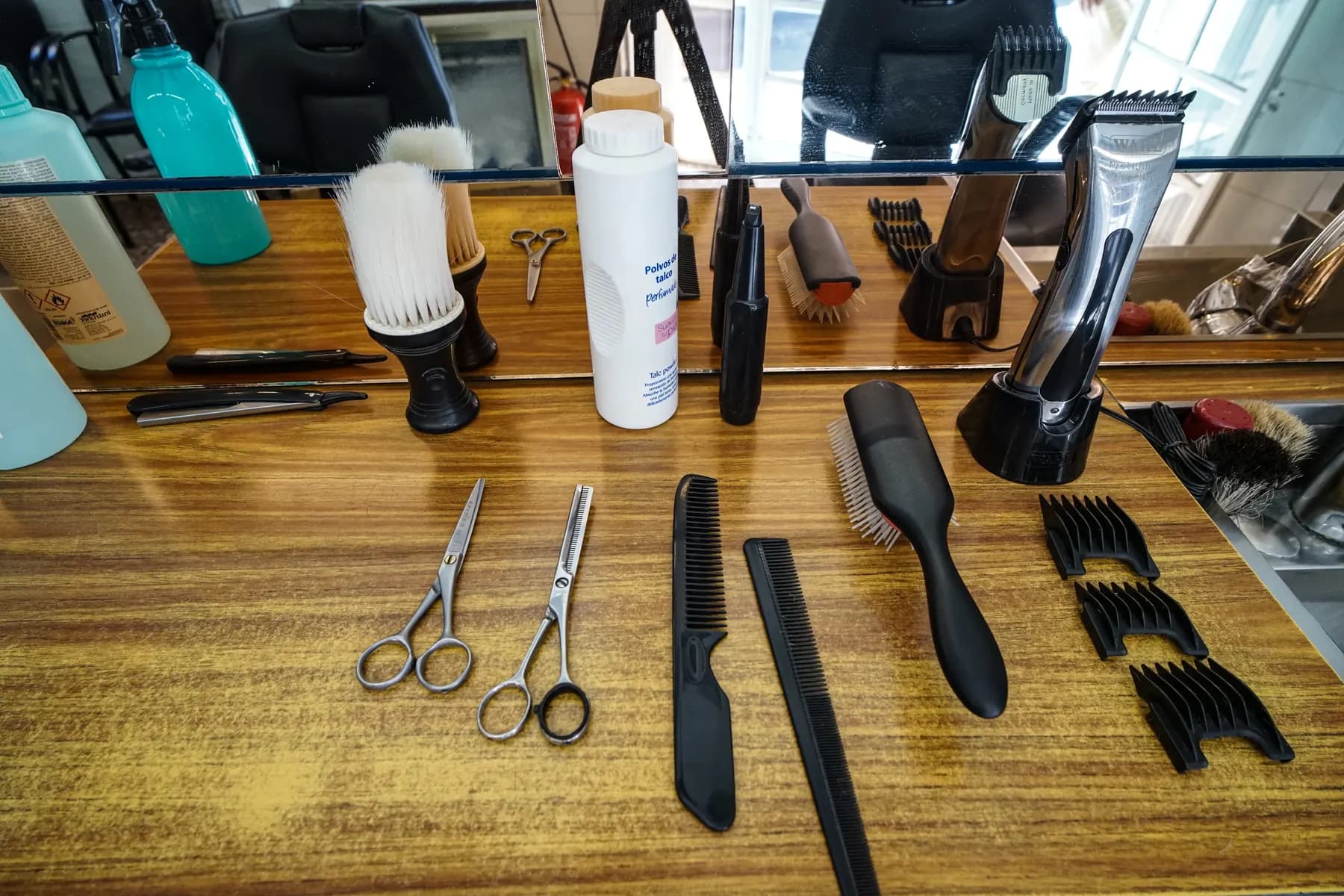 Shears, combs and clippers lined up on the studio bench